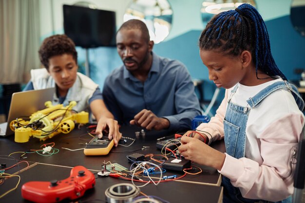 side-view-portrait-young-black-girl-building-robots-with-male-teacher-background-engine_236854-42973.jpg